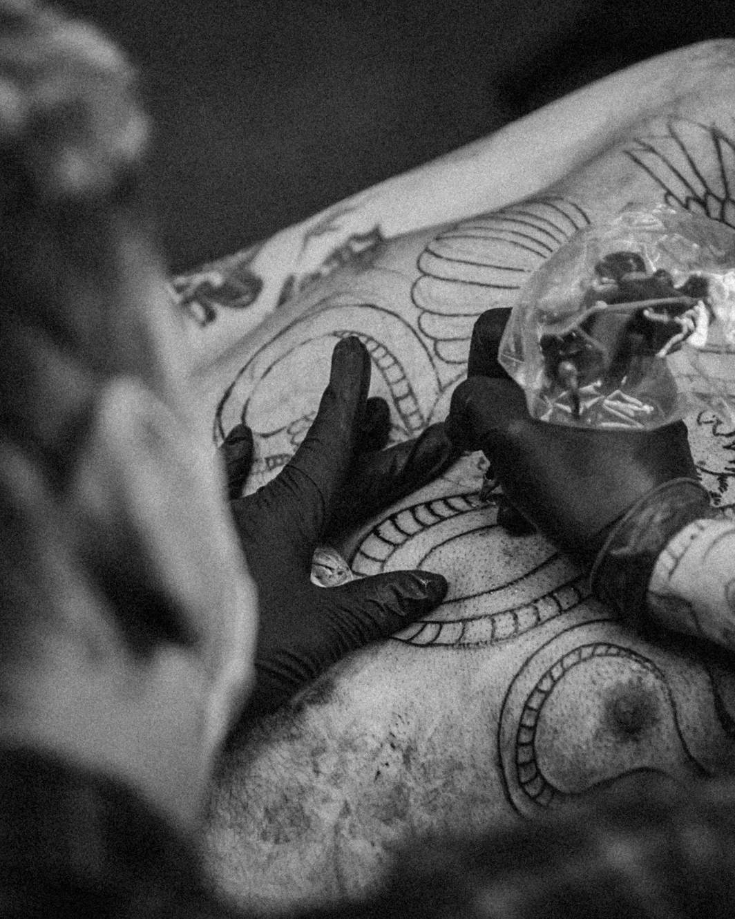 Tattoo artist working on a large linework back tattoo at Dreamline Tattoo Uluwatu